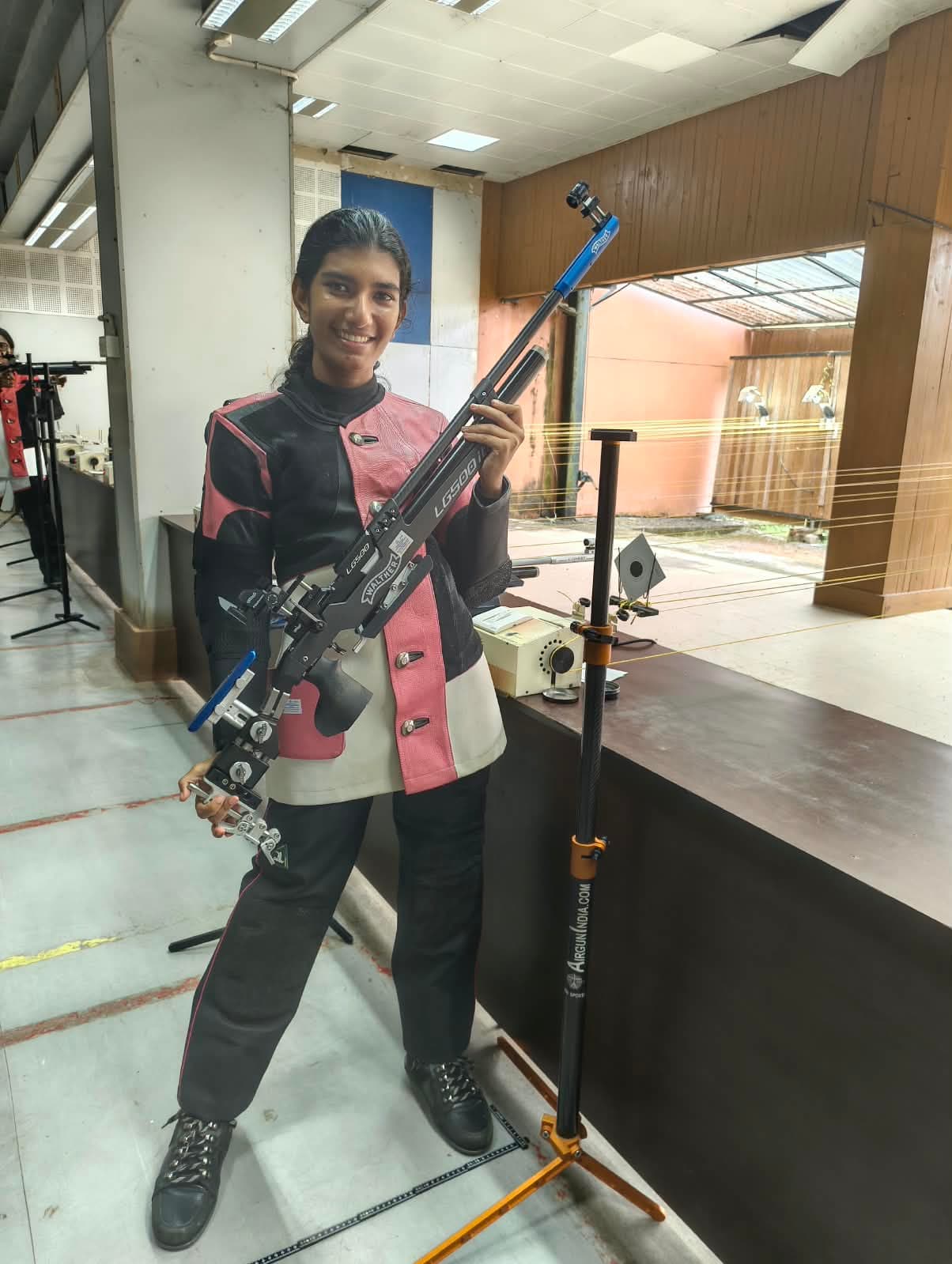 Brahmitha G smiling and holding her air rifle at the practice range